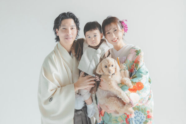 白い背景で和装の二人と子どもと犬が並ぶ写真