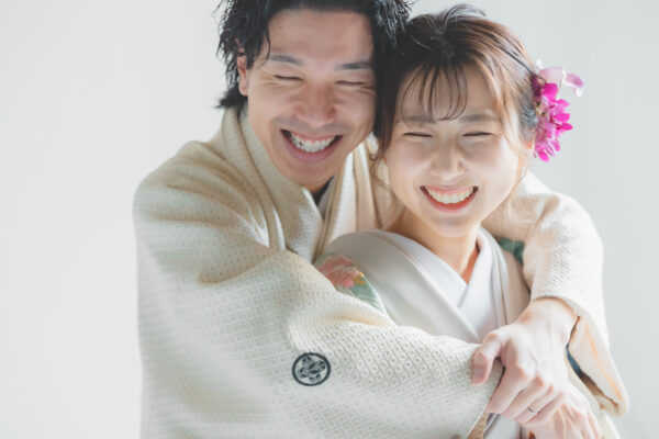 和装の二人が笑顔で抱きしめ合う写真